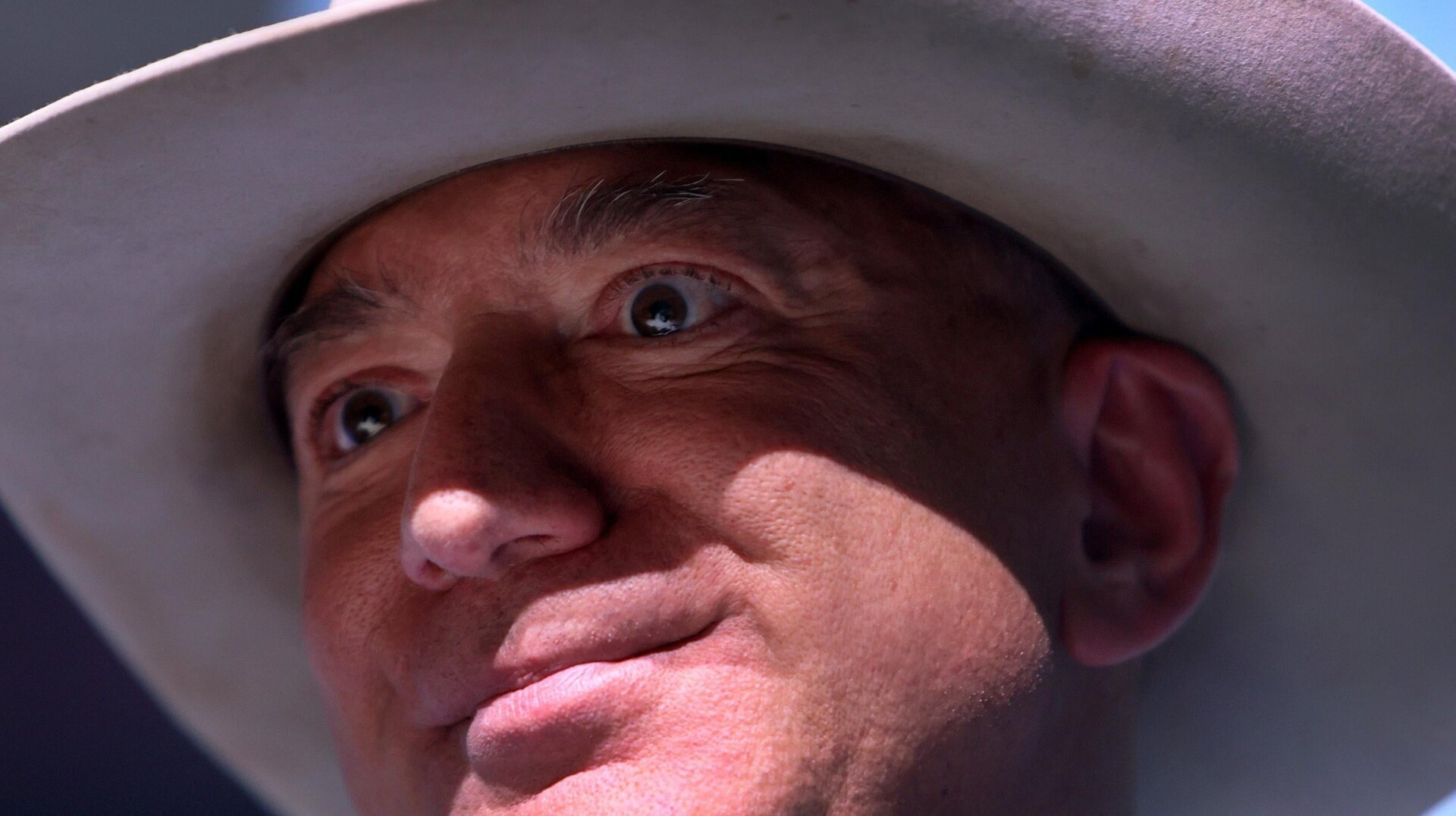 Jeff Bezos in a cowboy hat, staring intently into the camera.