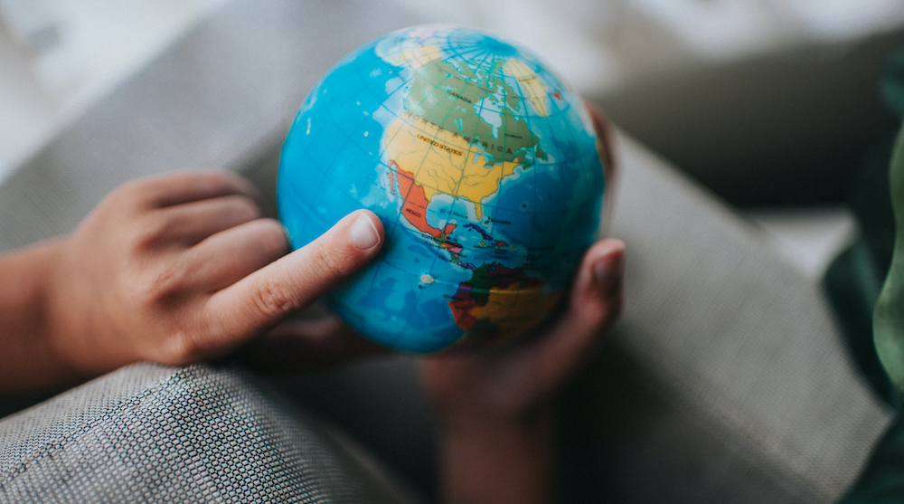 Child pointing to a globe