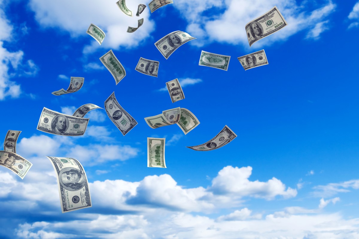 U.S. Money falling from a partly cloud sky.