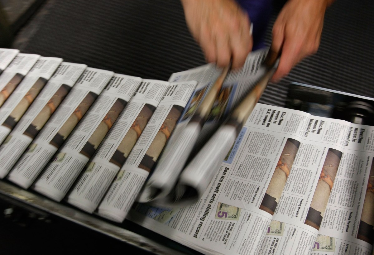 A photo of a stream of newspapers on the printing press.