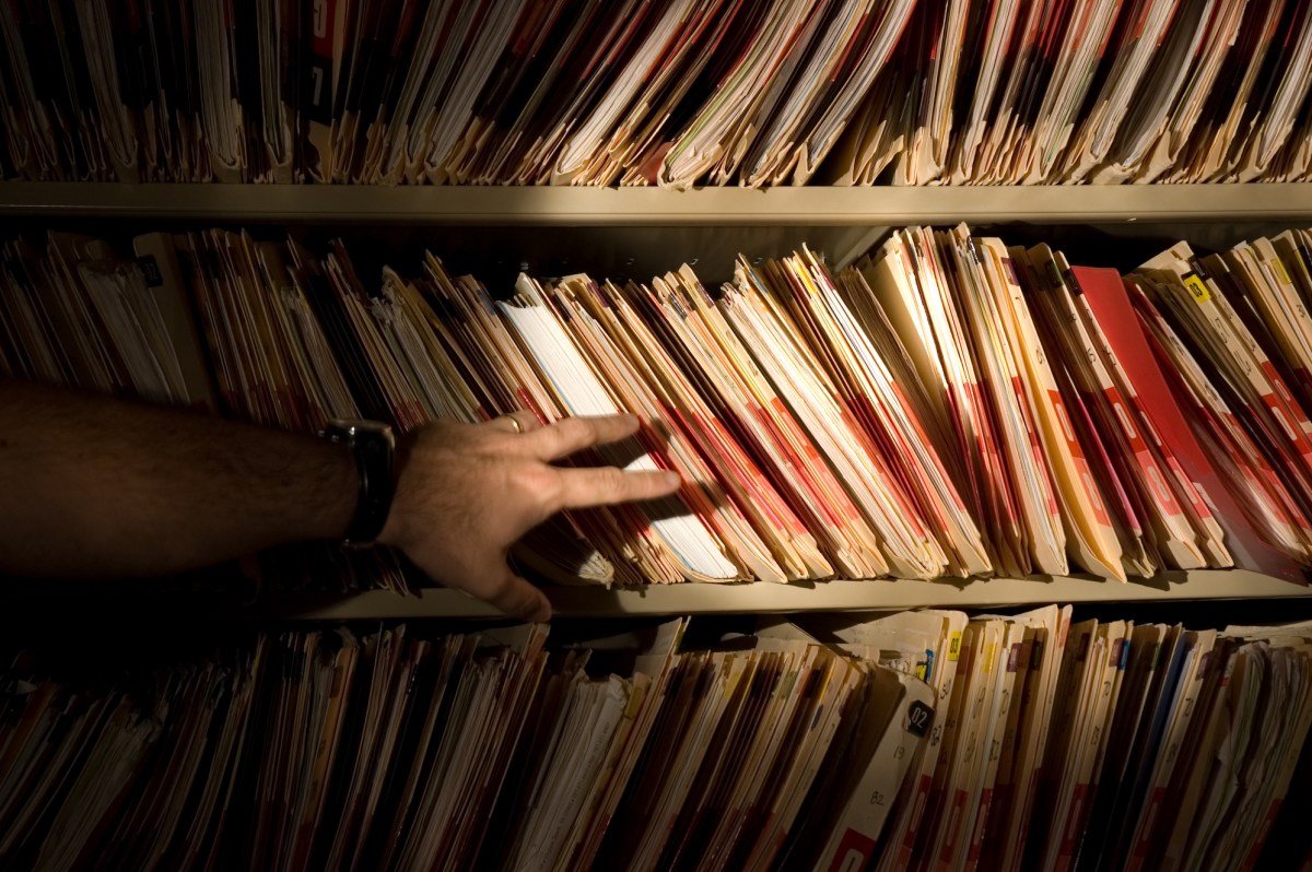 tons of medical records on a shelf in a darkened room