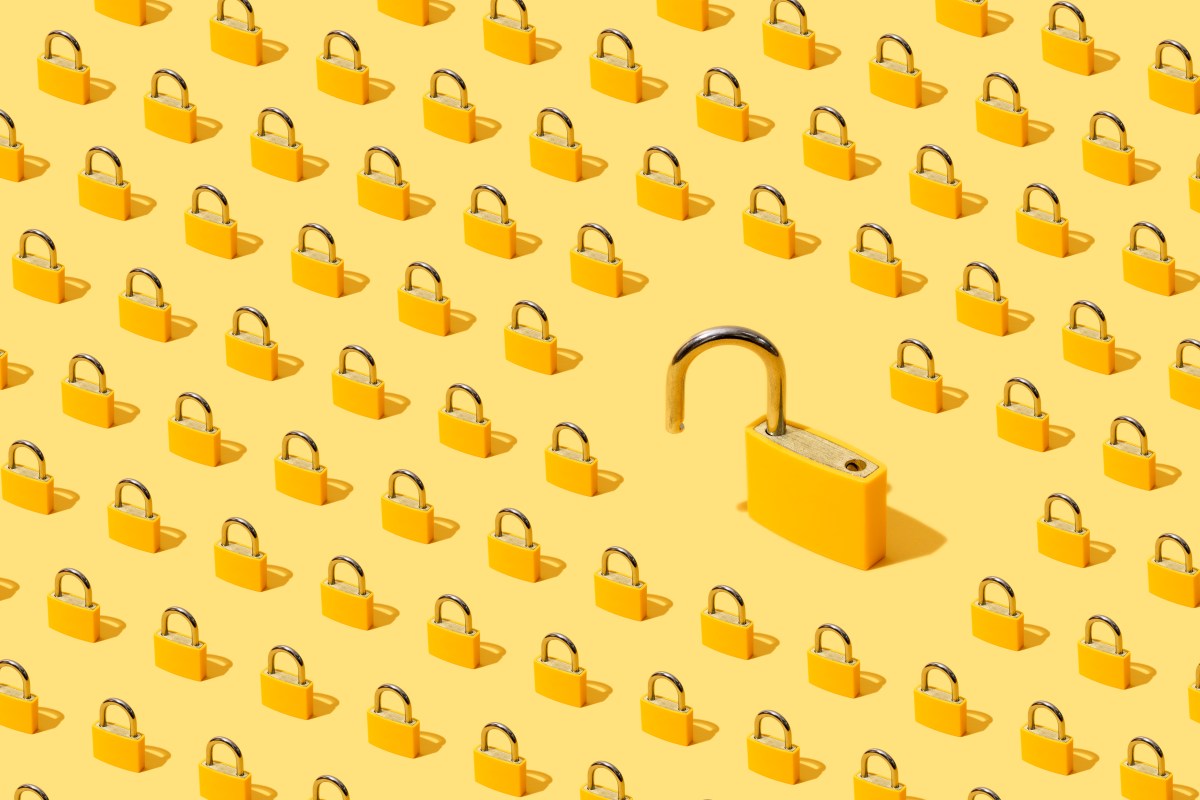 High-angle view of yellow padlocks on yellow background. One of them is open.