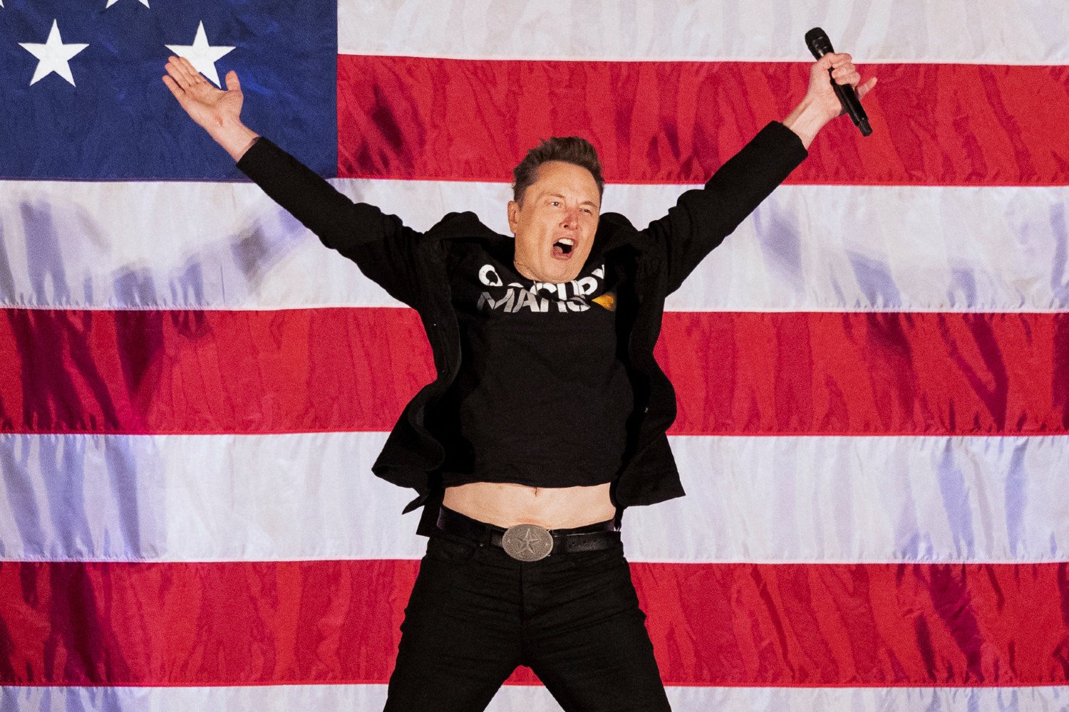Elon Musk jumps awkwardly at an event before the 2024 election to promote Donald Trump at the Greater Philadelphia Expo Center in Oaks, Pennsylvania, on October 18, 2024.