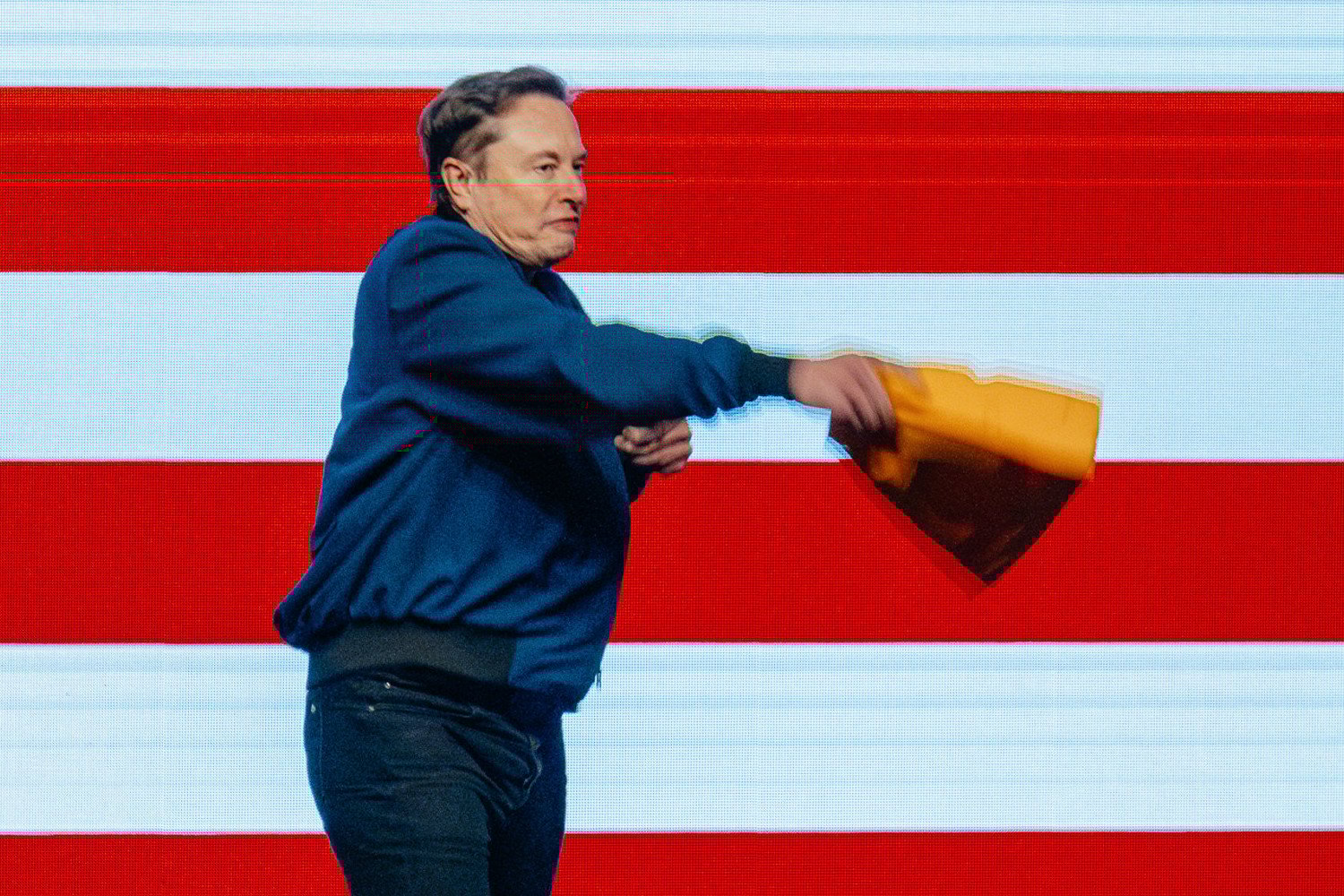 Elon Musk tosses a signed cheesehead hat into the audience during an America PAC town hall ahead of the Wisconsin Supreme Court election at the KI Convention Center in Green Bay, Wisconsin, US, on Sunday, March 30, 2025.