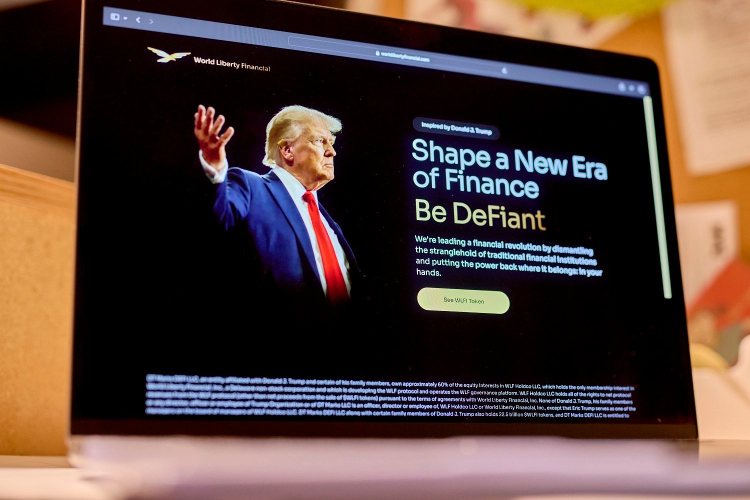 The World Liberty Financial website, including a photo of Donald Trump, displayed on a laptop